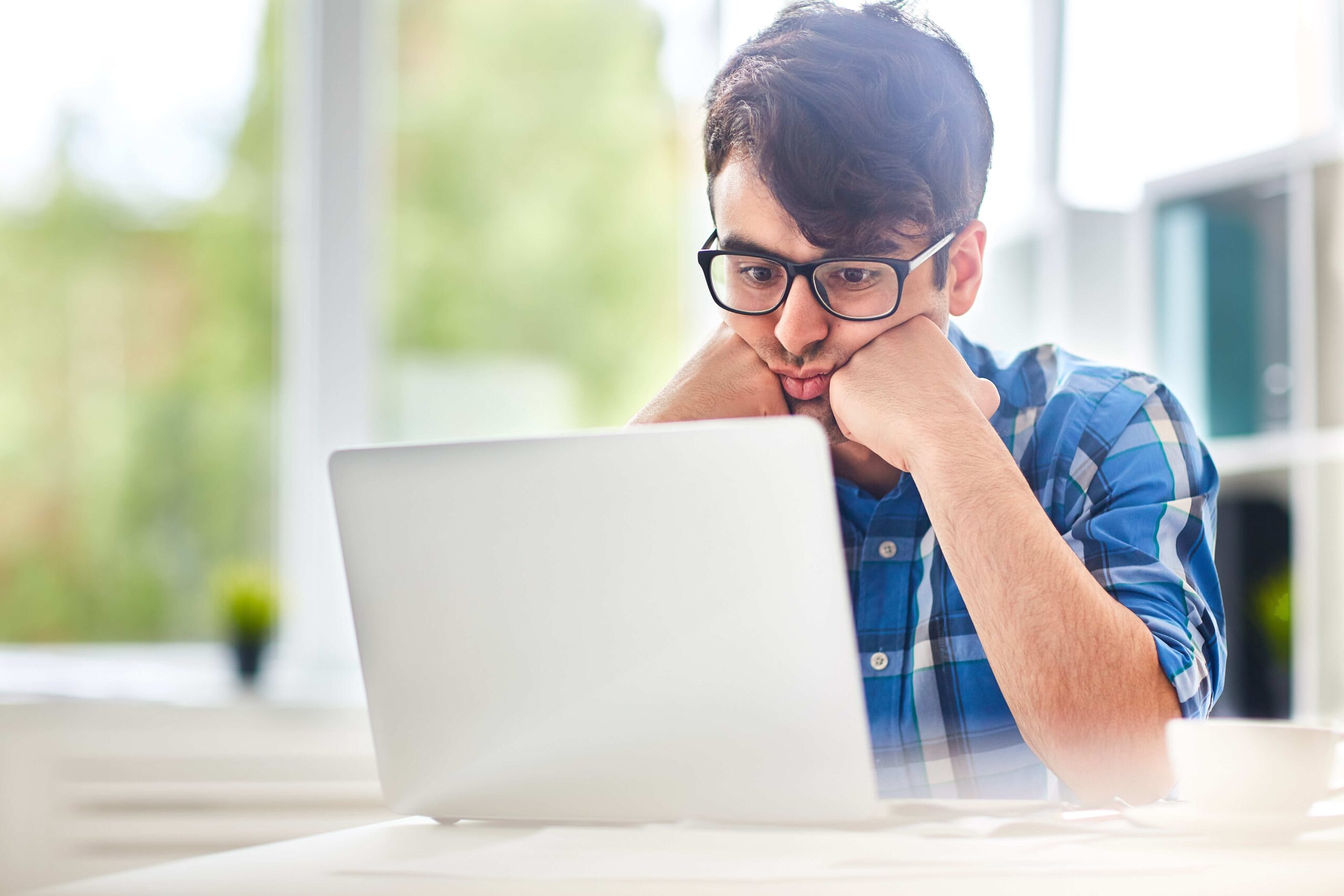 Marketer comparing AI search engine optimization services pricing on a laptop